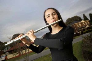 Young flautist focused in one direction